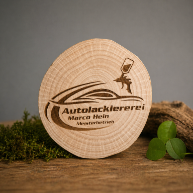 Autolackiererei Hein Holzscheibe mit Lasergravur des Logos "Autolackiererei Marco Meis" und dekorativem Hintergrund.