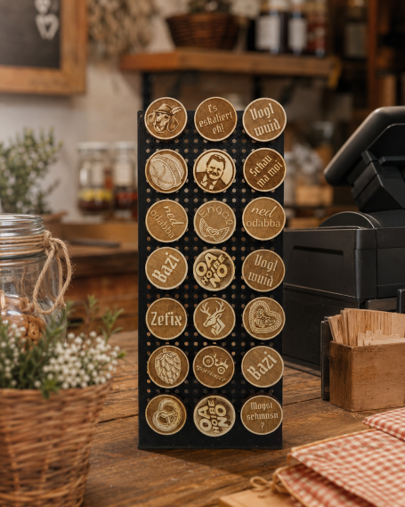 Trachtenpins im Kassendisplay Ein Gestell mit runden Holzplättchen, jede mit einem einzigartigen Motiv graviert.