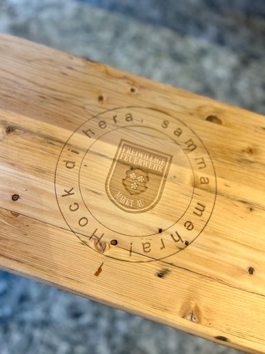 FFW Au i.d. Hallertau Holztisch mit eingeprägtem Wappen und Schriftzug in der Mitte.