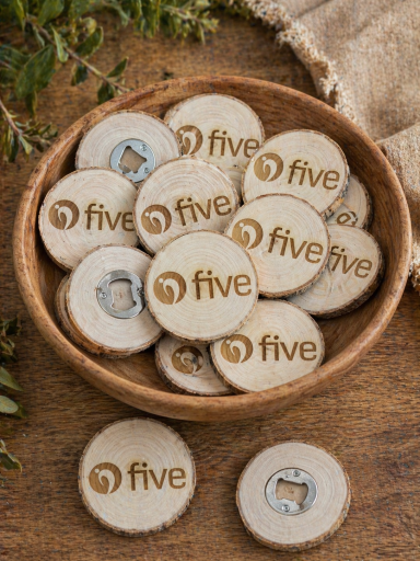 Five-Konzept GmbH & Co. KG Holzscheiben mit dem Aufdruck „five“ in einer Schüssel auf einem Holztisch.