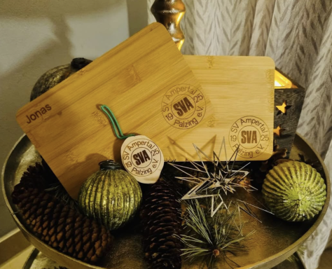 Spielverein Ampertal Palzing e. V. Zwei Holzschneidebretter auf einem dekorierten Tisch mit winterlicher Deko.